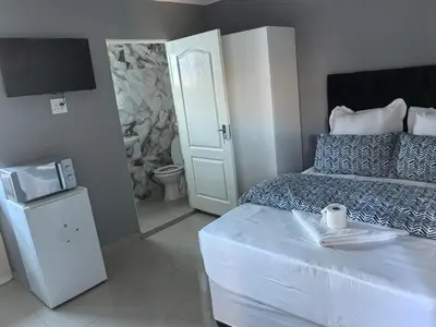 a small bedroom with a bed and a television at Gift Guest house 2 in Cravenby