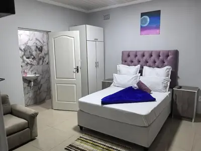 a bedroom with a bed with a blue blanket on it at Gift Guest house 1 in Cravenby