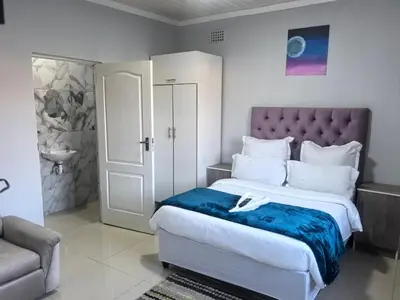 a bedroom with a large bed with a purple headboard at Gift Guest house 1 in Cravenby