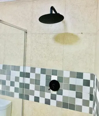 a shower with a glass door and a black light at Cottage in Cape Town