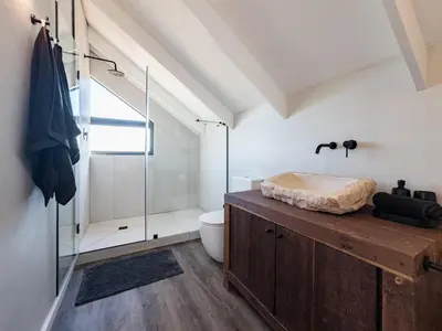 a bathroom with a toilet and a glass shower at Breedekloof Kajuit in Romansrivier