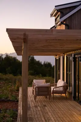 a deck with two chairs and chairs on a house at Breedekloof Kajuit in Romansrivier