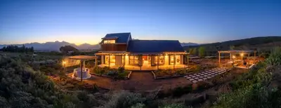 a house on a hill with its lights on at Breedekloof Kajuit in Romansrivier