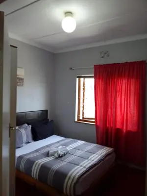 a bedroom with a bed with a red curtain at At-home Oakdale Bellville in Bellville