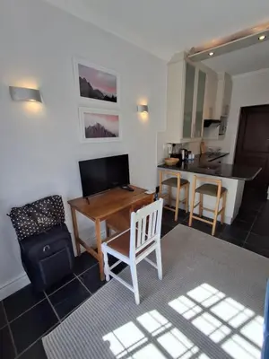 a living room with a table and a kitchen at Studio 5 at Huis Piron in Stellenbosch