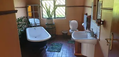 a bathroom with two sinks and a toilet and a window at Protea-Sabr in Sir Lowry Pass