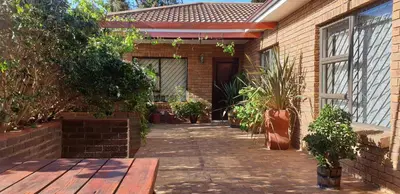 a brick house with a pathway leading to a door at Protea-Sabr in Sir Lowry Pass