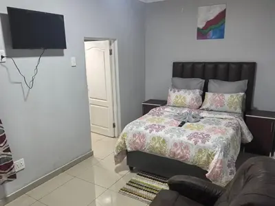 a bedroom with a bed and a couch and a television at Gift Guest house 3 in Cravenby