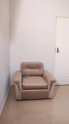 a brown couch sitting in a room with a door at Gift Guest house 3 in Cravenby