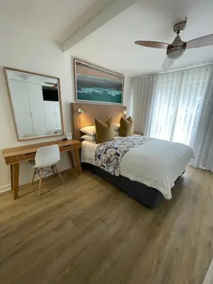a bedroom with a bed and a desk and a chair at Gordonia Unit 9 Gordons Bay in Gordonʼs Bay