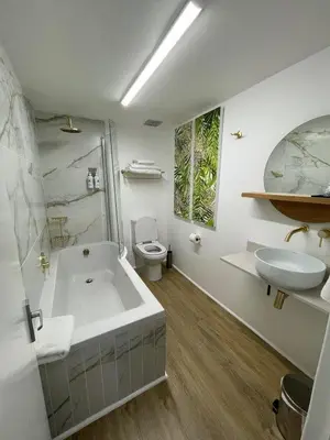 a bathroom with a tub and a toilet and a sink at Gordonia Unit 9 Gordons Bay in Gordonʼs Bay