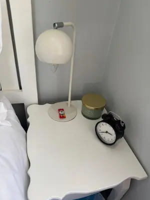 a white bedside table with a lamp and a clock at The Protea & Vine - Paarl - Self Catering Apartment in Paarl