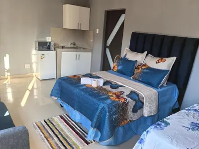 a bedroom with a bed with a blue comforter at Gift guest house 4 in Cravenby
