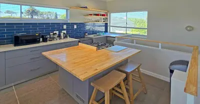 a kitchen with a wooden counter top and blue tiles at Cape Town Studio Apartment in Cape Town