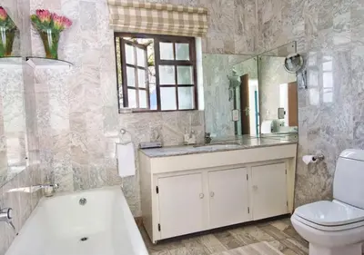 a bathroom with a tub and a toilet and a sink at Wildeberg Elephants Trail Cottage in Franschhoek