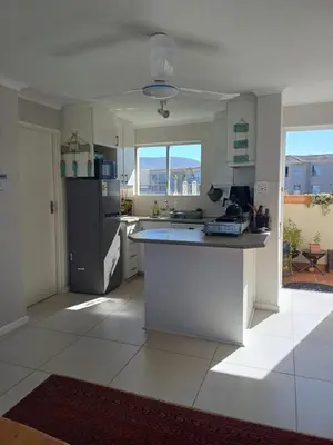 a kitchen with a refrigerator and a counter top at Beach Club 150 Hermanus in Hermanus