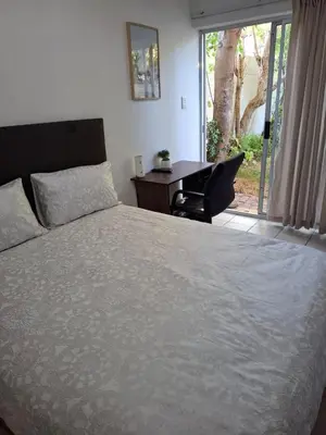 a bedroom with a bed and a desk and a window at Chez Yves 2 in Hoheizen