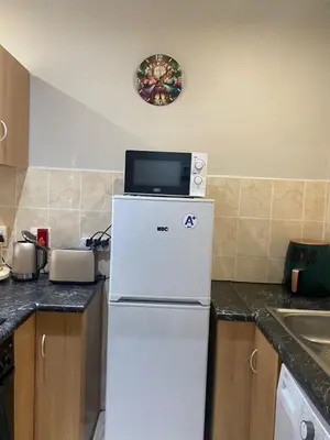 a refrigerator with a microwave on top of it in a kitchen at Melk Tert - Paarl - Self Catering Apartment in Paarl