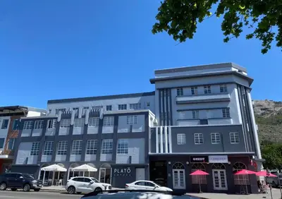 a large building with cars parked in front of it at Melk Tert - Paarl - Self Catering Apartment in Paarl
