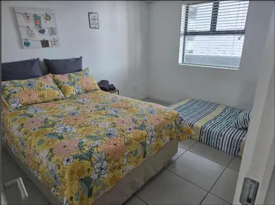 a bedroom with a bed and a window at Sunset at Keys in Cape Town
