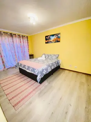 a bedroom with a bed in a room with yellow walls at GWMV Guest House in Cape Town