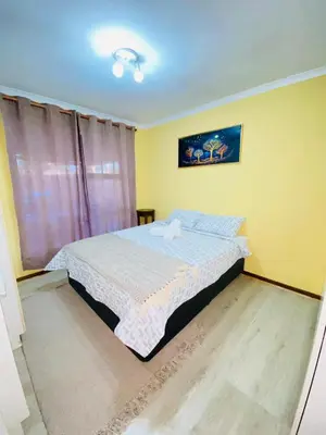 a bedroom with a bed in a room with yellow walls at GWMV Guest House in Cape Town