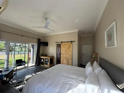 a bedroom with a large white bed and a window at La Vita Farm Stay in Wellington