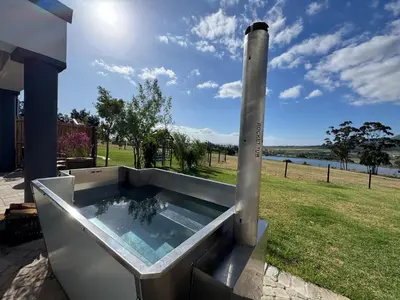 a hot tub on the side of a house at La Vita Farm Stay in Wellington