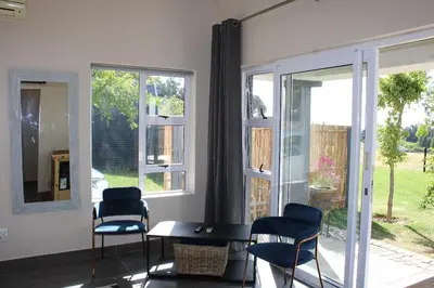 a room with two chairs and a table and windows at La Vita Farm Stay in Wellington