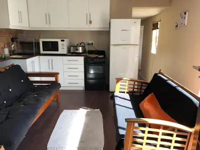 a living room with a couch and a kitchen at Home from Home in Welton