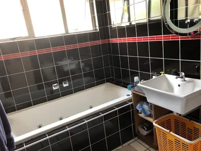 a bathroom with a bath tub and a sink at Home from Home in Welton