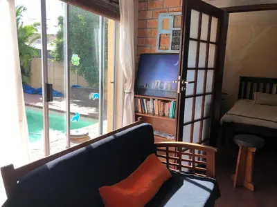 a living room with a couch and a tv and a pool at Home from Home in Welton