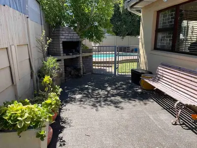 a patio with a bench and some plants and a fence at Home from Home in Welton