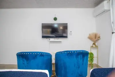 two blue chairs in a room with a tv at Optimum Stay Self Catering Accommodation - Twin Room 2 Single Beds in Parow