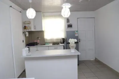 a kitchen with a vase of flowers on a counter at Optimum Stay Self Catering Accommodation - Twin Room 2 Single Beds in Parow