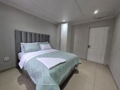 a bedroom with a large bed with a blanket on it at Maglovir Economy in Tiervlei