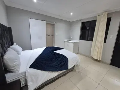 a bedroom with a bed with a blue blanket on it at Maglovir Economy in Tiervlei