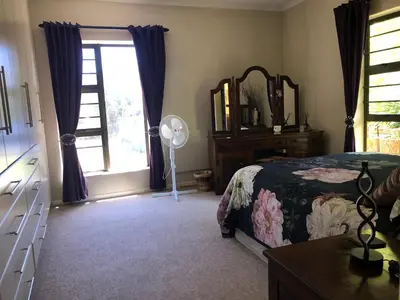 a bedroom with a bed and a dresser and a mirror at Charming Self-Catering Apartment in Tygerberg Hills