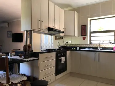 a kitchen with white cabinets and a stove top oven at Charming Self-Catering Apartment in Tygerberg Hills