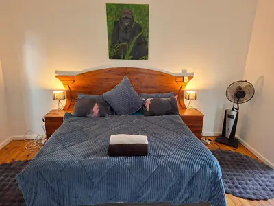 a bedroom with a bed with a blue comforter at Leigh's home with dogs in Cape Town