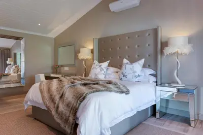a bedroom with a large bed with a large headboard at The Jordan Suites in Stellenbosch