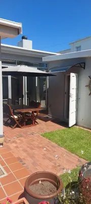 a patio with a table and chairs on a house at Amanda's Place in Hermanus