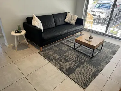 a living room with a black couch and a table at Black & White Self Catering in Paarl