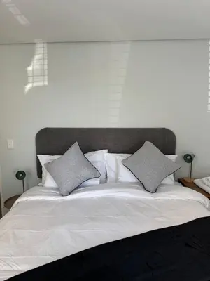 a large white bed with two pillows on it at Black & White Self Catering in Paarl