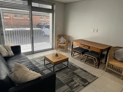 a living room with a couch and a table at Black & White Self Catering in Paarl