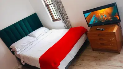 a bedroom with a bed and a television on a dresser at Self catering accommodation in Cape Town