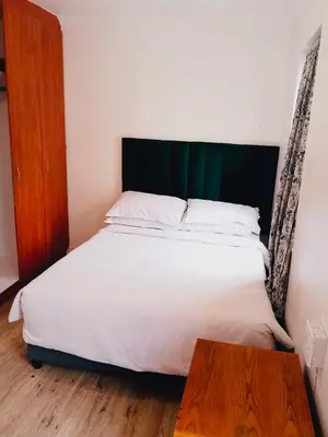 a bedroom with a bed and a wooden table at Self catering accommodation in Cape Town