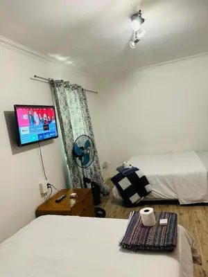 a bedroom with two beds and a tv on the wall at Self catering accommodation in Cape Town