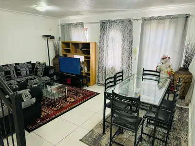 a living room with a glass table and a couch at Self catering accommodation in Cape Town