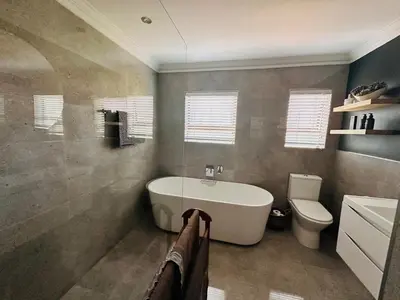 a bathroom with a tub and a toilet and a sink at Lelani Self Catering Cape Town in Oakdale